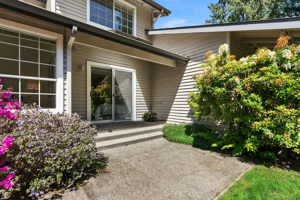 Landscaped entry walkway and patio doors at a Puget Sound property shot by Vourly